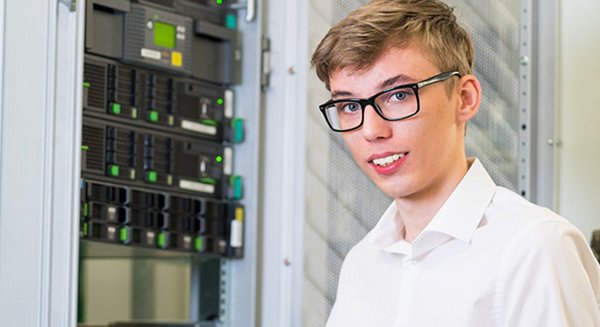 Die Duale Student für Fachinformatik für Anwendungstechnik Oliver Kirsch steht in einem Serverraum.